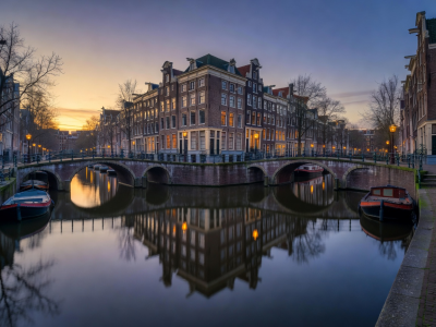 Amsterdam canal houses illuminated during an evening boat cruise